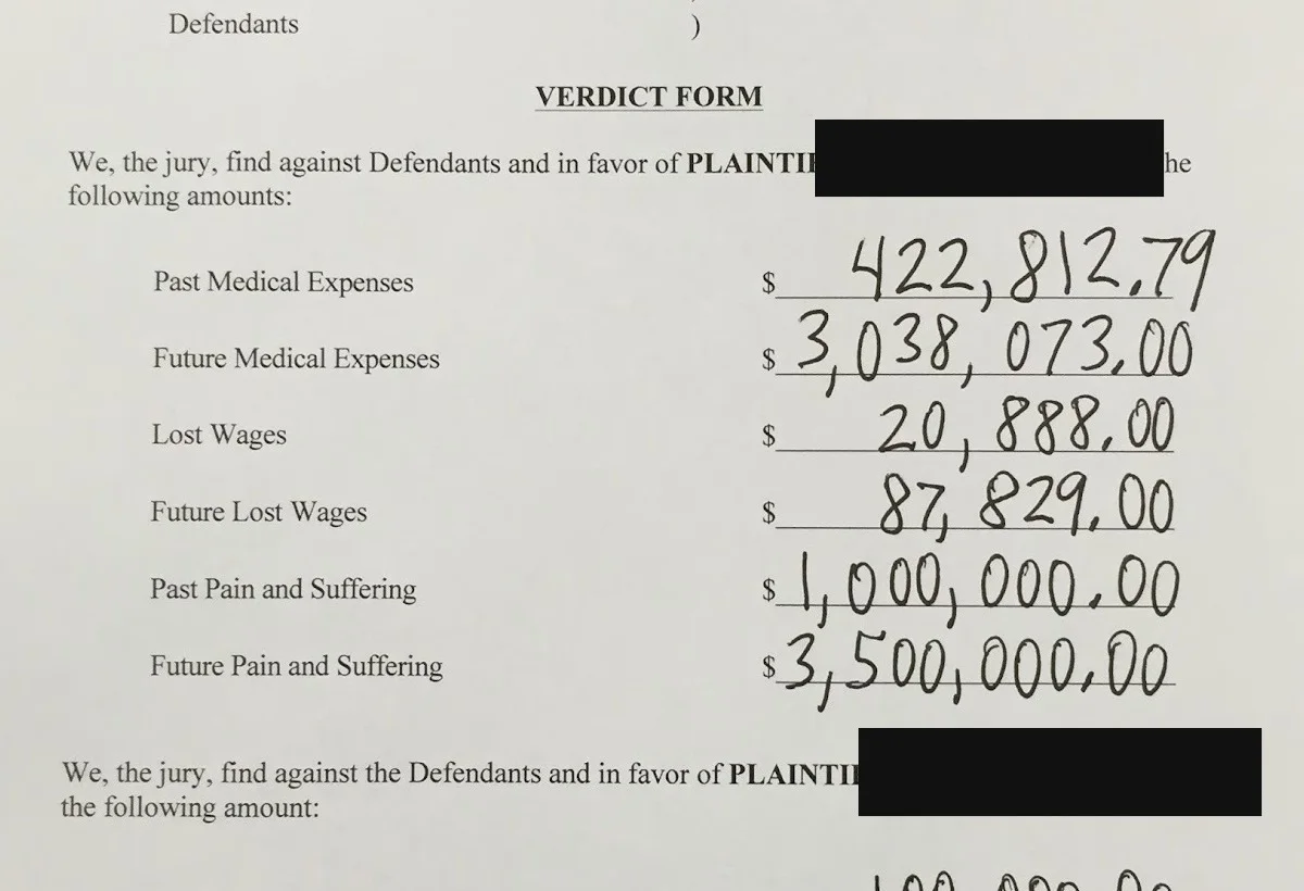 Redacted excerpt of the signed verdict form showing the jury's damages awards