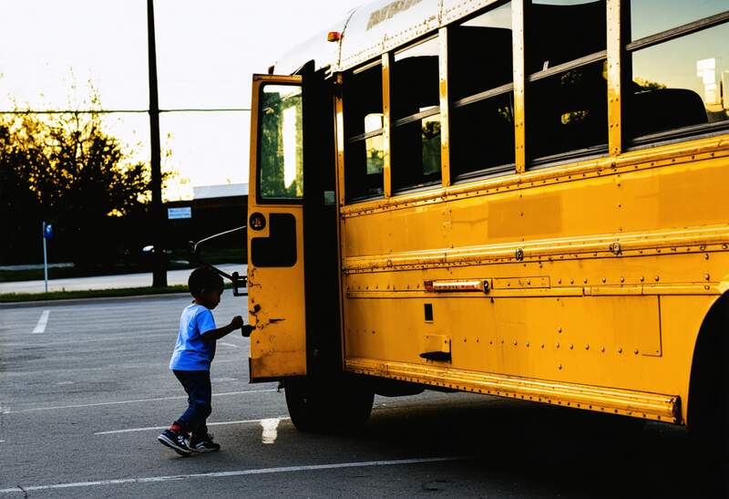 A kid entering a school bus